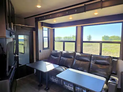 Living room with leather sofa and large windows